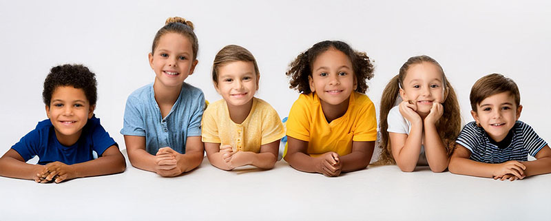 Six children lying down facing the camera