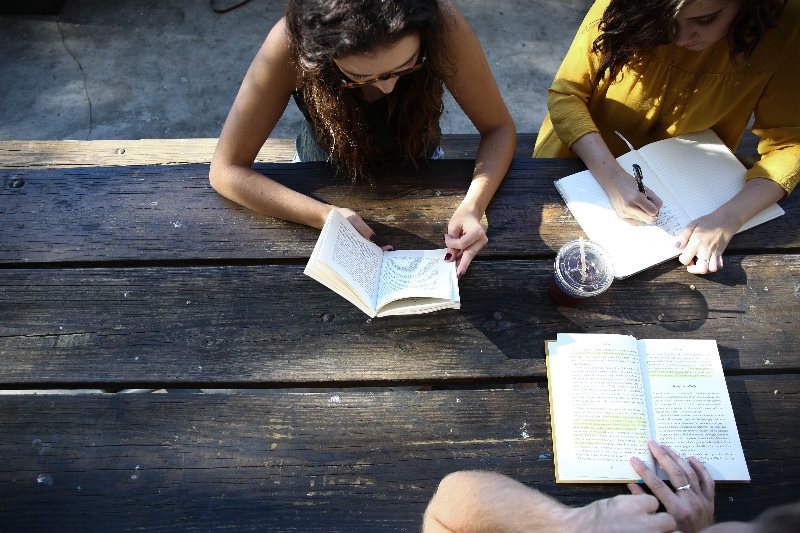 People sitting at a desk reading 