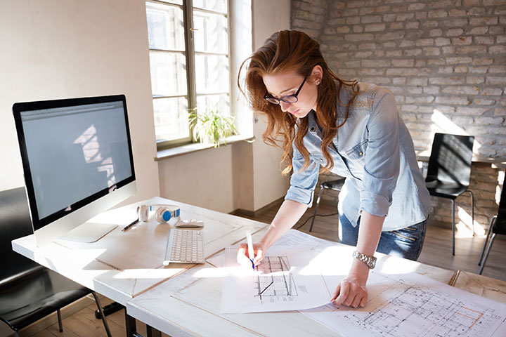 Projects: Woman working on plans at desk