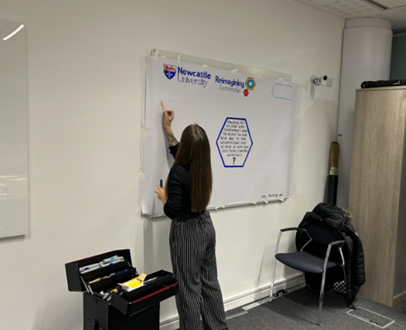 Person drawing the graphic on a poster