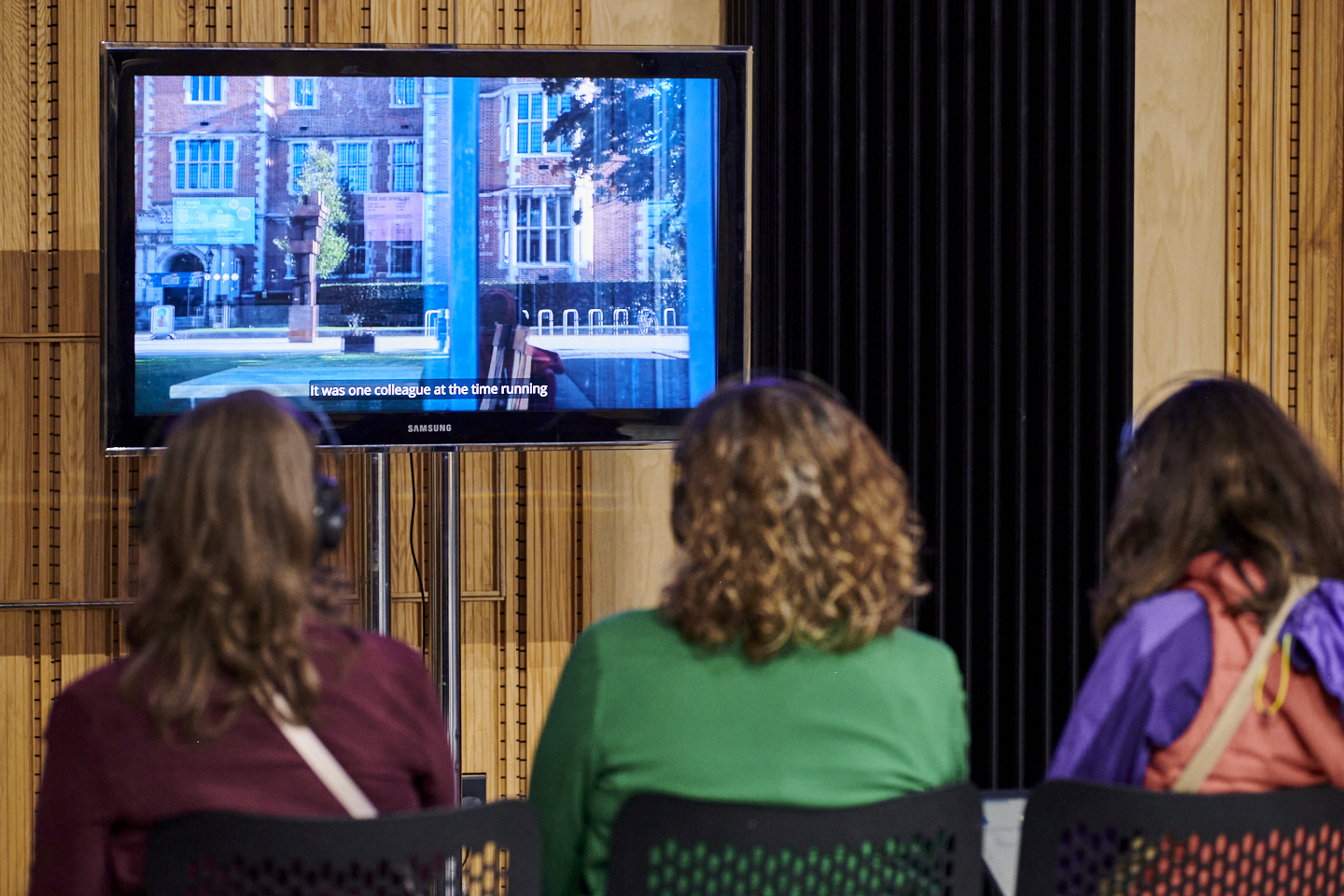 Three people watching a TV Three people watching a TV